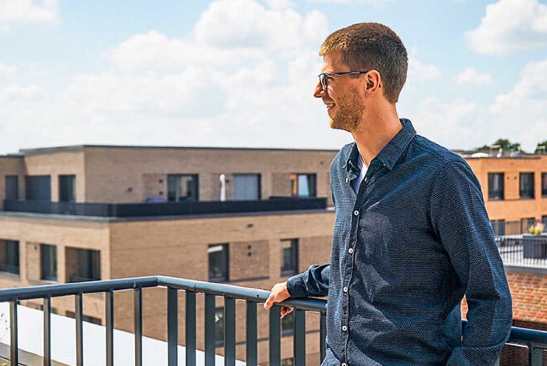 Ein Mann steht auf einem Balkon