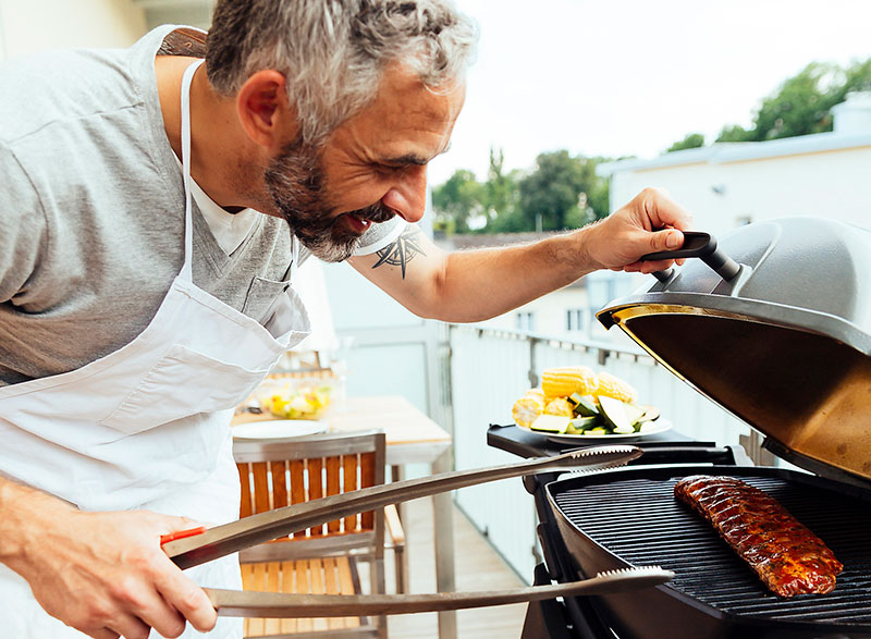 Mann checkt sein Grillgut