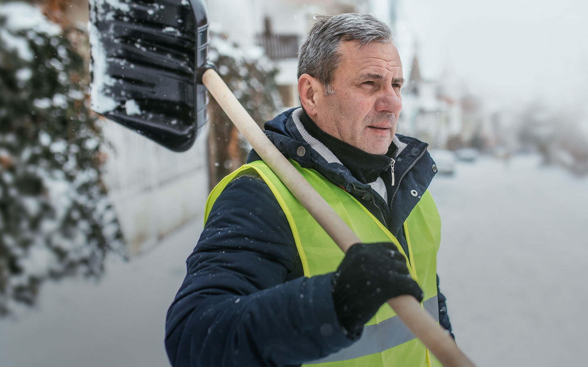 Mann im Schnee mit Schneeschaufel