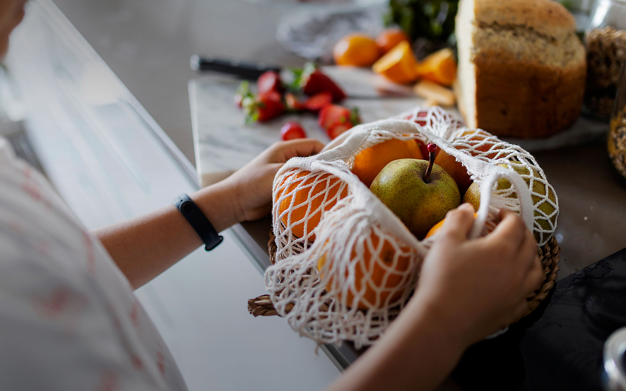 Nahaufnahme eines Jungen beim Auspacken von Obst auf der Küchentheke