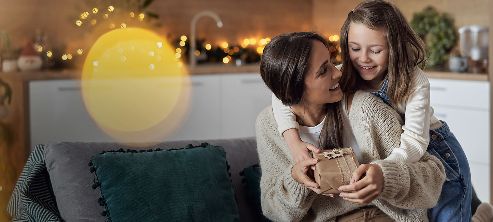 Die Tochter überreicht ihrer Mutter ein Geschenk.