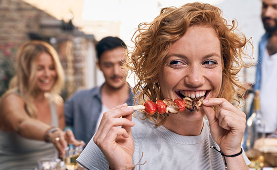 Frau beißt in Grillspieß